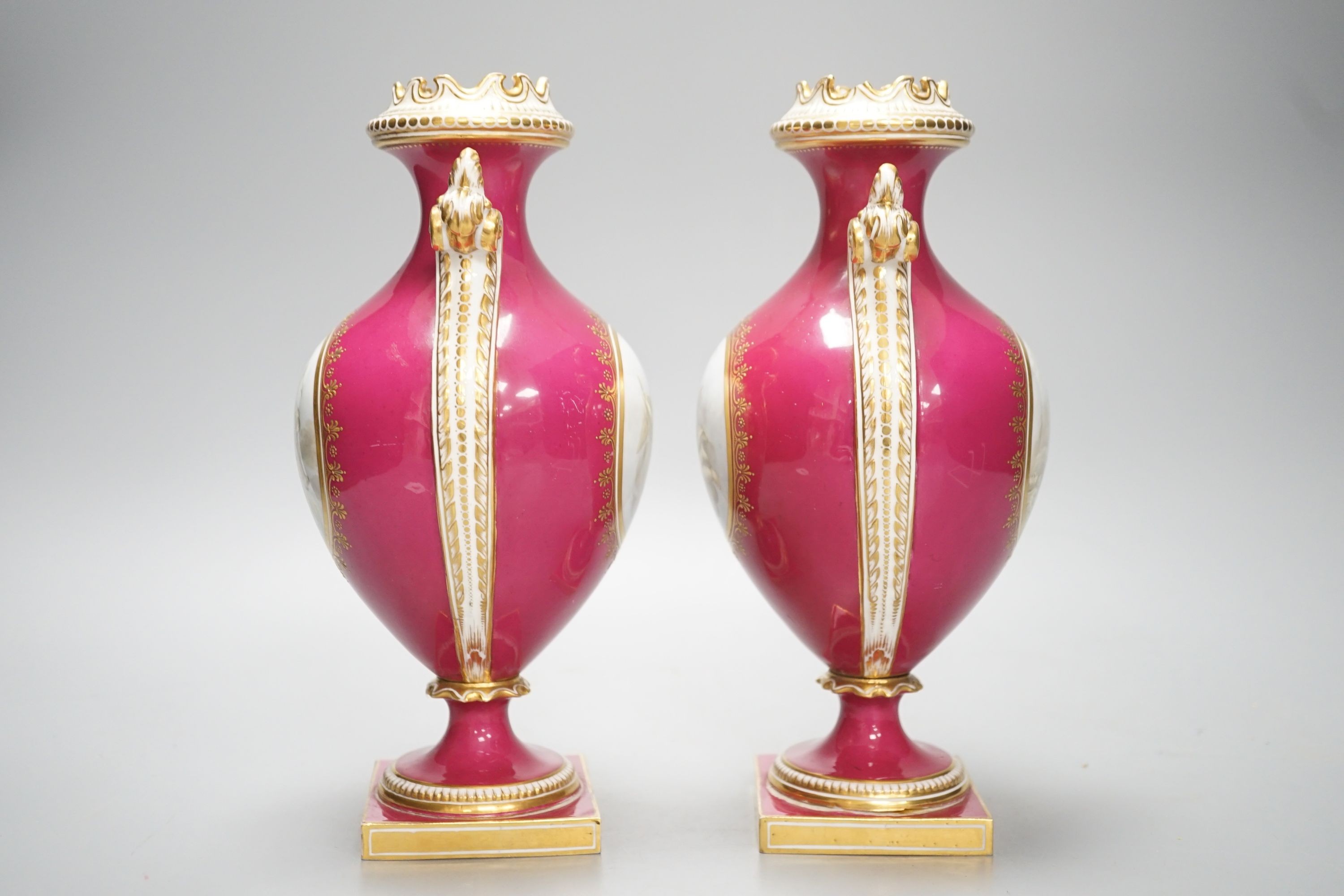 A pair of Coalport vases painted en-grisaille with cherubs in Chelsea style on a crimson ground, CSN mark in gold to one, height 23.5cm